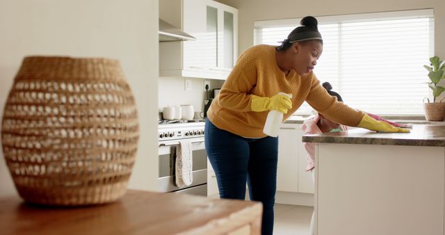 African American Woman Cleaning Kitchen Counter with Daughter in Background - Download Free Stock Images Pikwizard.com