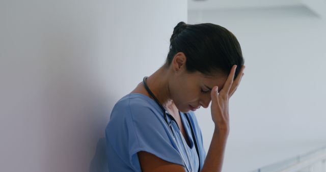 Image depicts a nurse in a hospital feeling overwhelmed and stressed, conveying themes of burnout and workplace pressure. Use for articles on healthcare challenges, mental health in medical professions, or workplace stress. Relevant for healthcare editorials, blogs on mental wellness, and social media posts supporting medical professionals.
