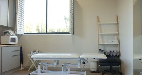 Bright medical examination room with empty treatment table