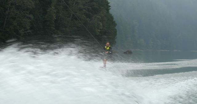 Person Wakeboarding on Lake with Dense Forest Background - Download Free Stock Images Pikwizard.com