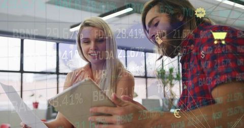 Coworkers collaborating with technology in modern open office