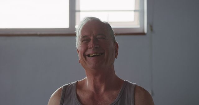 Cheerful senior man laughing in casual indoor setting - Download Free Stock Images Pikwizard.com