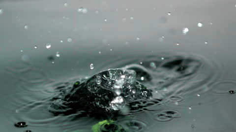 Splashing Green Bell Pepper in Water Creating Ripples and Bubbles
