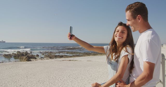 Smiling Couple Taking Selfie at Beautiful Beach on Sunny Day - Download Free Stock Images Pikwizard.com