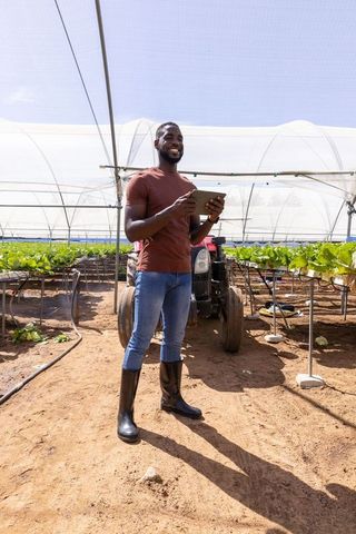 Urban farmer using tablet for precision agriculture in greenhouse