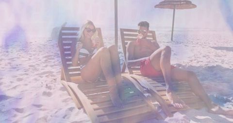 Couple Relaxing on Tropical Beach with Refreshing Drinks