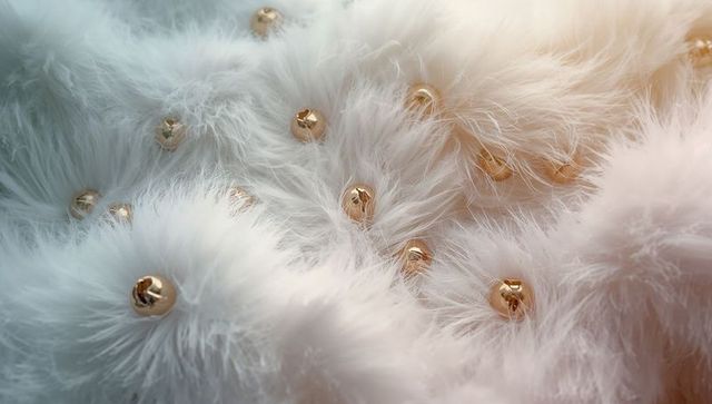 Luxurious white faux fur with gold beads capturing elegance and texture