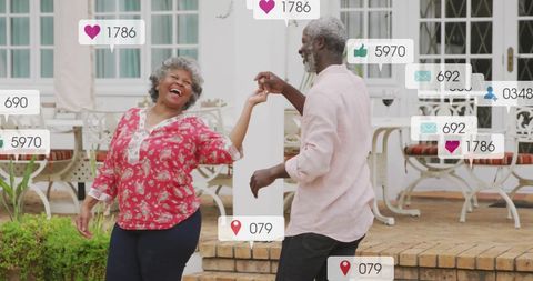 Joyful Senior Couple Dancing Outdoors Surrounded by Social Media Icons