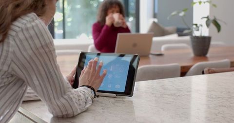 Women Collaborating at Home with Modern Tablet Technology