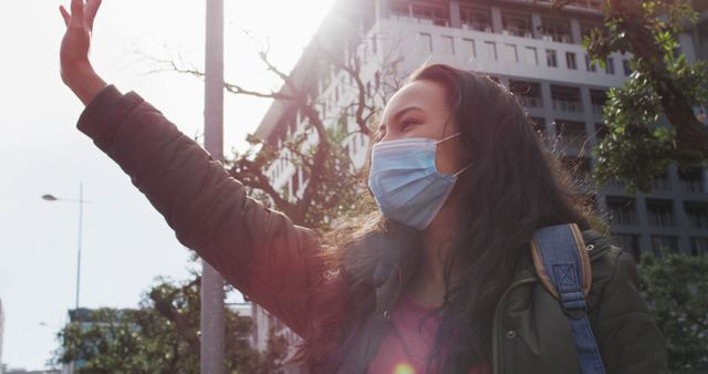 Young Woman in Face Mask Hailing Taxi on City Street - Download Free Stock Images Pikwizard.com