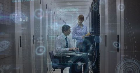 Technicians in server room analyzing digital data interfaces