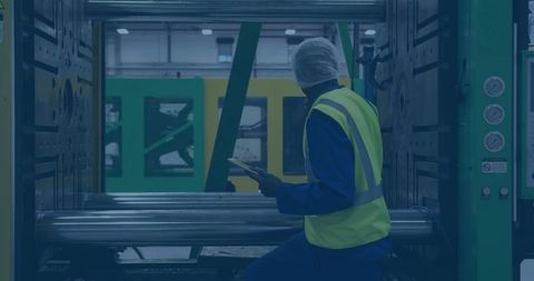 Technician analyzing injection molding machine in manufacturing facility