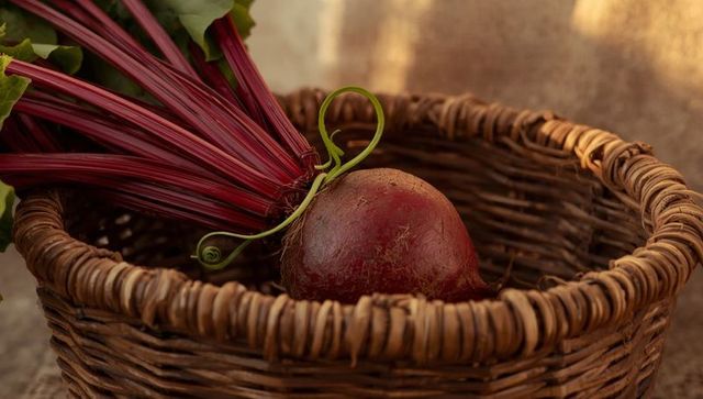Fresh beetroot in wicker basket on rustic table