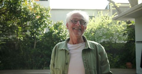 Senior Man Relaxing in Sunlit Backyard Garden