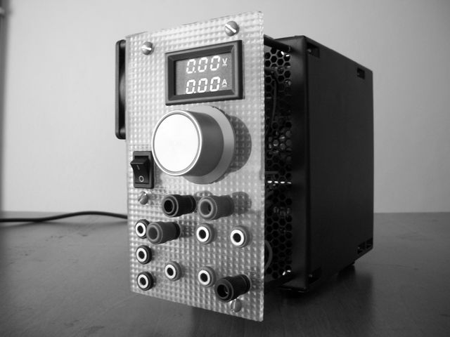 Features black and white power supply unit with digital voltage display. Suitable for use in electronic projects, laboratories, and industrial environments. Ideal for illustrating concepts of modern electronics, science, and engineering.