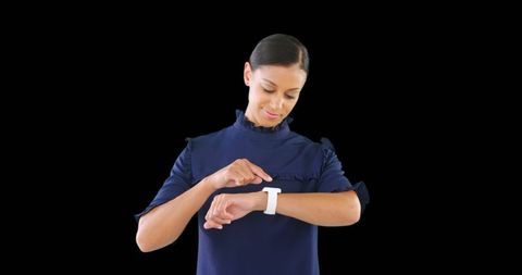 Businesswoman Checking Smartwatch Against Dark Background - Download Free Stock Images Pikwizard.com