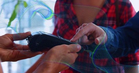 Hands holding and pointing at portable device with holographic augmented reality overlay