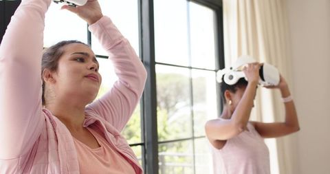 Women trying virtual reality headsets in bright living room, lifestyle tech fun