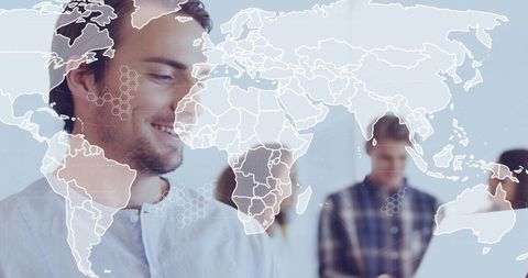 Smiling professional in light shirt with world map overlay and hex ui for global teamwork