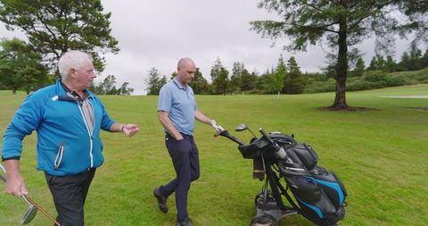 Senior Friend Pair Enjoying Leisurely Golf on Course Fairway