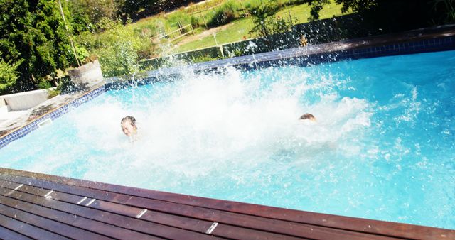 Two people are enjoying a refreshing splash in an outdoor swimming pool on a sunny day, with copy space. Their energetic activity creates a dynamic and fun atmosphere, perfect for summer leisure.