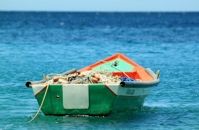 Small Fishing Boat Floating on Turquoise Ocean - Download Free Stock Photos Pikwizard.com