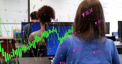Diverse Team Analyzing Financial Data on Monitors in Office Environment