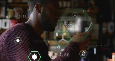 Man scrolling on smartphone wearing maroon sweater in cozy dim cafe with ar data overlays