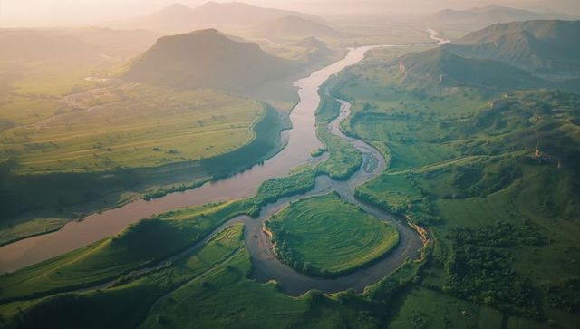 Serene aerial view of meandering river through verdant valley