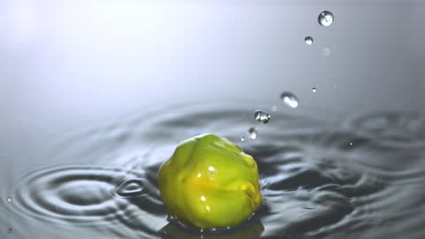 Green Chili Splash in Water Creating Ripples