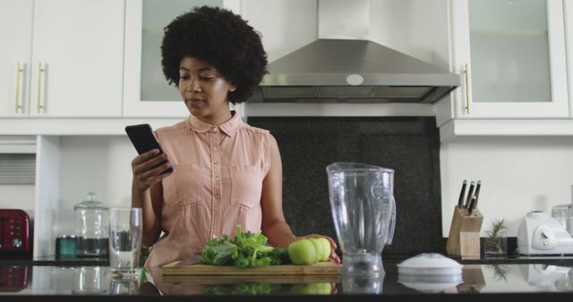 Woman Preparing Healthy Smoothie following Recipe on Smartphone in Modern Kitchen - Download Free Stock Images Pikwizard.com