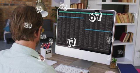 Man working at minimalist home desk analyzing code on desktop monitor with floating numbers
