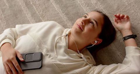 Woman Relaxing at Home Listening Music on Smartphone