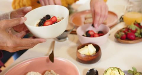 Senior couple sharing healthy breakfast bowl with berries and avocado