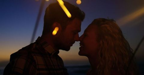 Romantic Couple Holding Sparklers at Beach During Dusk