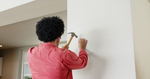 Man skillfully using hammer for home improvement in modern kitchen