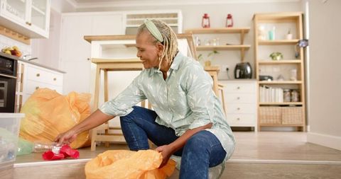 Senior Woman Sorting Recycling at Home with Care