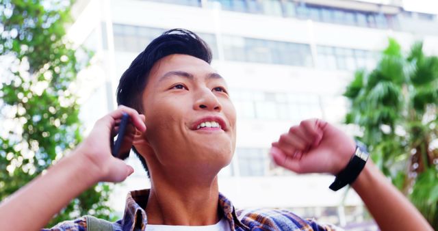 Excited Young Asian Man Celebrating Success Over Phone Outdoors - Download Free Stock Images Pikwizard.com
