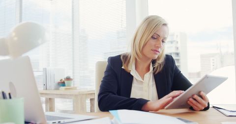 Focused Businesswoman Working on Tablet in Bright Office - Download Free Stock Images Pikwizard.com