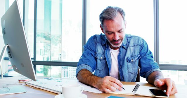 Middle-aged man working at desk in modern office - Download Free Stock Images Pikwizard.com