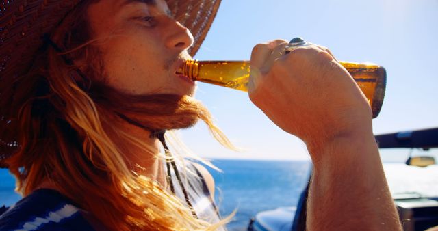 Young Man Drinking Beer by the Ocean on a Sunny Day - Download Free Stock Images Pikwizard.com