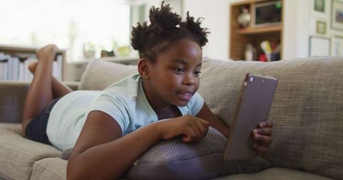 African American Girl Engaged with Tablet on Cozy Couch - Download Free Stock Images Pikwizard.com