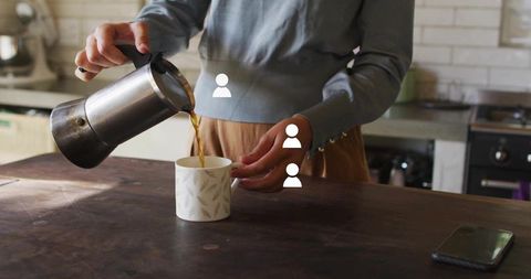 Woman Pouring Coffee in Cozy Home Kitchen Interior