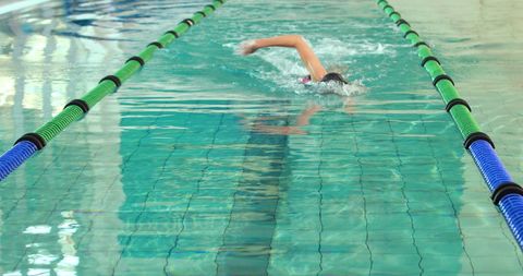 Active Swimmer Practicing Freestyle Stroke in Indoor Pool