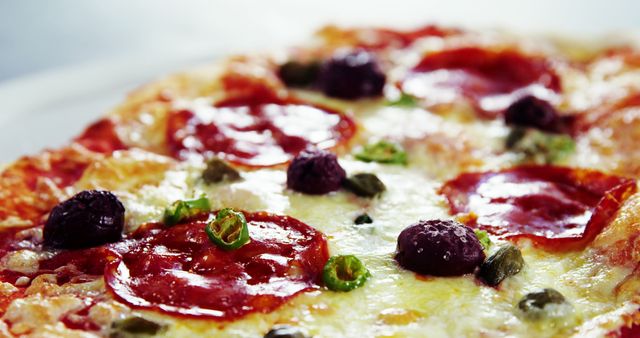 Appetizing close-up image of a pepperoni pizza with melted cheese, black olives, and green pepper slices. Perfect for use in advertisements, food blogs, recipe books, and social media posts promoting delicious Italian cuisine.