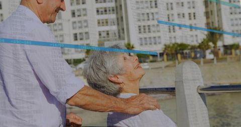 Senior couple enjoying sunny seaside promenade, man massaging partner's shoulders