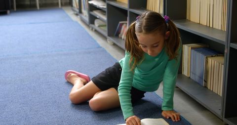 Young Girl Reading Book on Floor in School Library - Download Free Stock Images Pikwizard.com