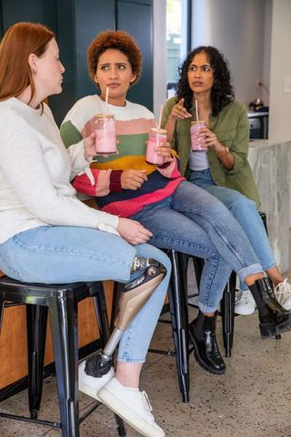 Diverse friends enjoying smoothie together in cafe