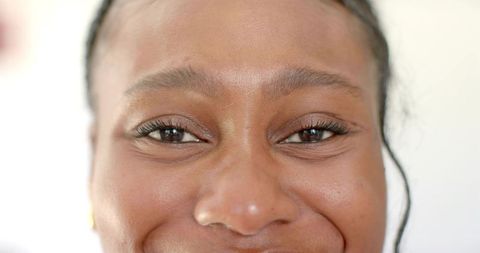 Close-Up Portrait of a Woman Smiling with Smooth Skin and Braided Hair