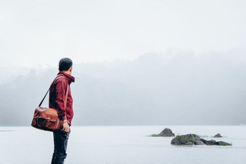 Man in Red Jacket Gazing at Misty River